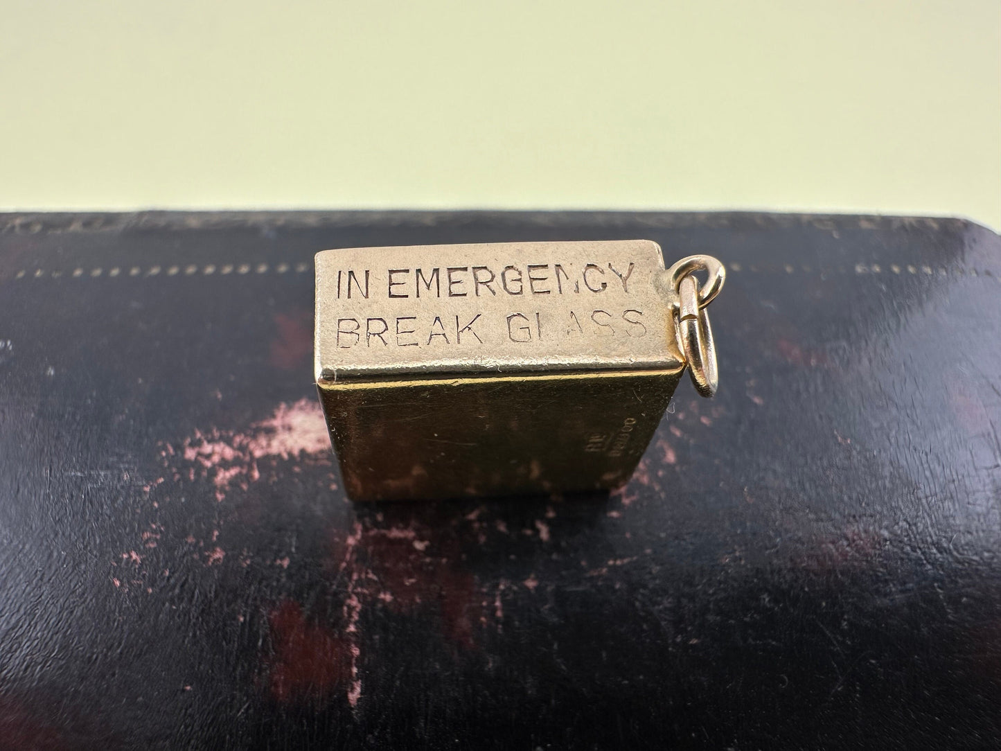 Vintage 9ct gold 10 shilling ‘in emergency break glass’ charm, 1969